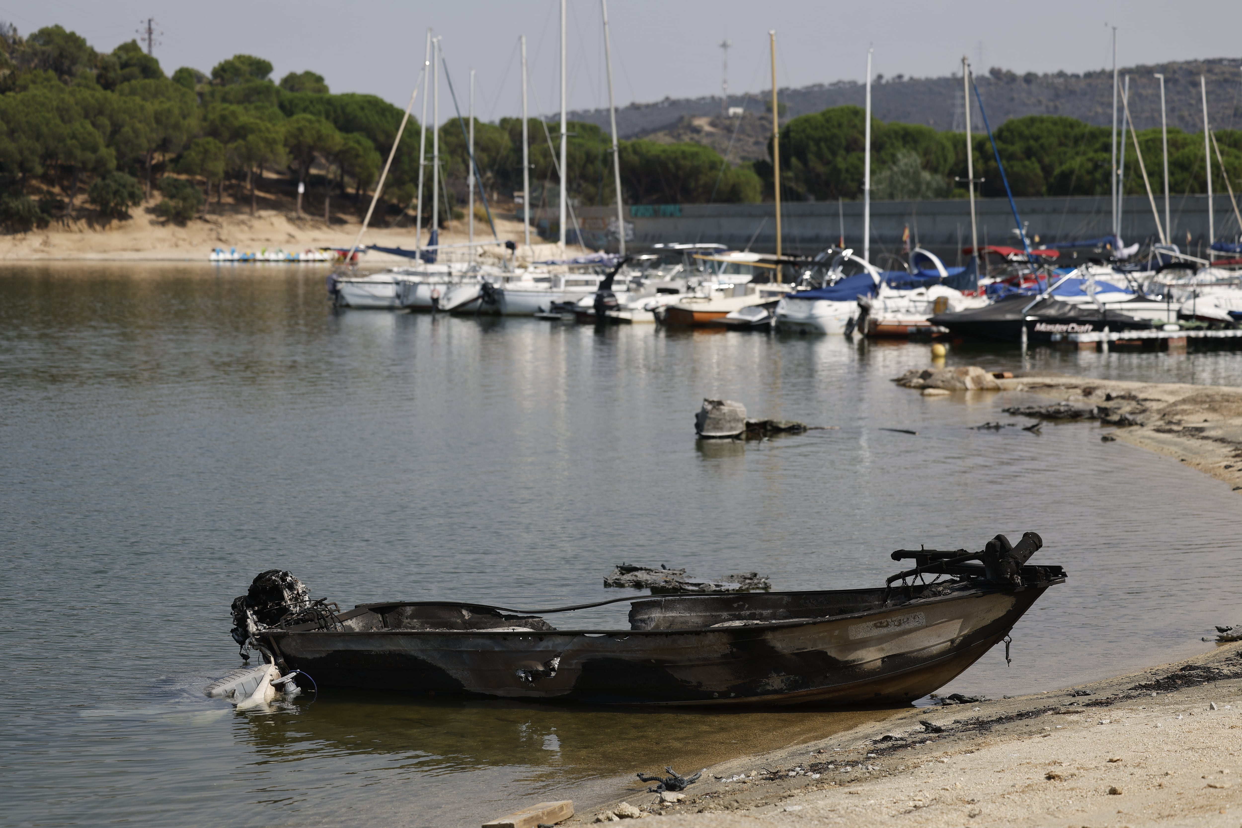Una barca completamente calcinada junto al pantano de San Juan, este martes.