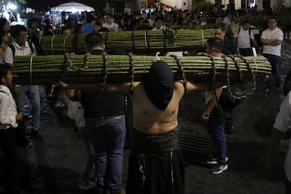 Hombres cargan rollos de varas de zarza con espinas en sus hombros durante la Procesión del silencio en Taxco (México). 