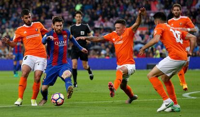 El delantero del Barcelona Leo Messi chuta a puerta ante la oposición de varios jugadores del Osasuna.