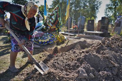 Lidia, de 76 años, ayuda a acabar de enterrar los restos de Vladislav Sopronchuk, muerto en el frente de Donbás, en el este de Ucrania