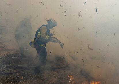 La compañía PG&E ha recibido críticas severas de los políticos del Estado, pero la realidad es que no pueden hacer nada al respecto. En la imagen, los bomberos de San Matteo trabajaban ayer para extinguir las llamas del incendio de Kincade en el condado de Sonoma, California.