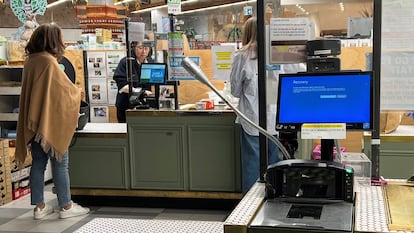 Una caja registradora muestra una pantalla azul en una tienda de comestibles afectada por un corte cibernético en Sídney, Australia.