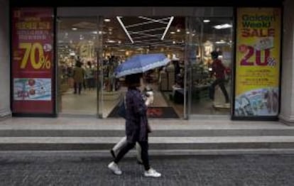 Dos mujeres surcoreanas pasan junto a una tienda que anuncia rebajas, en Seúl, Corea del Sur. EFE/Archivo