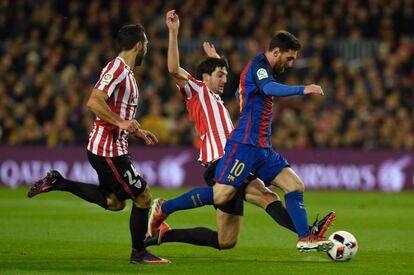 Messi se lleva el balón ante el acoso de los defensas del Athletic.