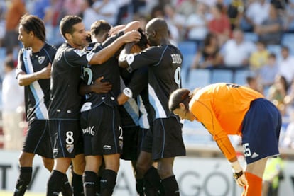 Los jugadores del Málaga se abrazan tras uno de sus goles ante la desolación de Leo Franco.