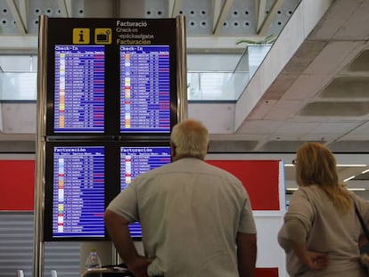 Pasajeros consultando vuelos en el aeropuerto de Palma de Mallorca.