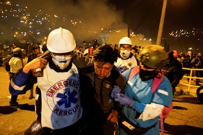 Un grupo de paramédicos asiste a un hombre cegado por los gases lacrimógenos lanzados por las fuerzas de seguridad ecuatorianas, en Quito, el 20 de junio de 2022.