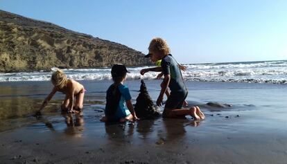 Tres niños juegan con la arena, una actividad con gran potencial educativo, según el pedagogo Gabriel Groiss.