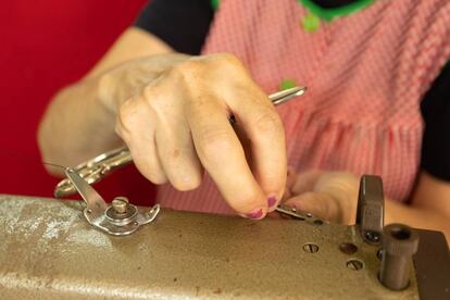 Antonia Rico coloca un hilo en la máquina de coser.