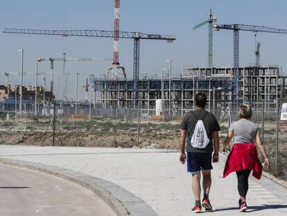 Dos personas pasean por barrio del Cañaveral (Vicálvaro), en plena construcción.