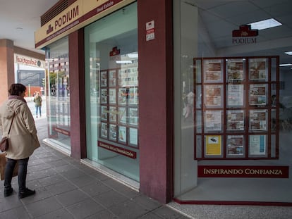 Una mujer mira los anuncios de compra venta de pisos en una inmobiliaria de Sevilla, este viernes.