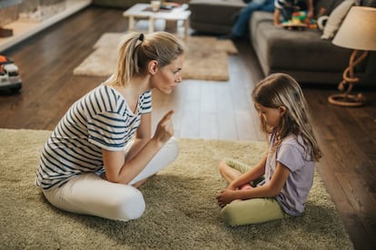 Una madre habla con su hija en el salón. 