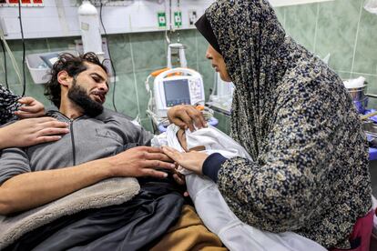 Un hombre herido se despide de su hijo fallecido mientras ambos yacen en un hospital de Rafah, en el sur de la Franja de Gaza, después del bombardeo nocturno por parte del ejército de Israel. 
