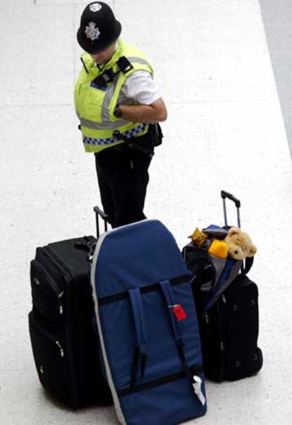 Un policía supervisa unas maletas en Liverpool.