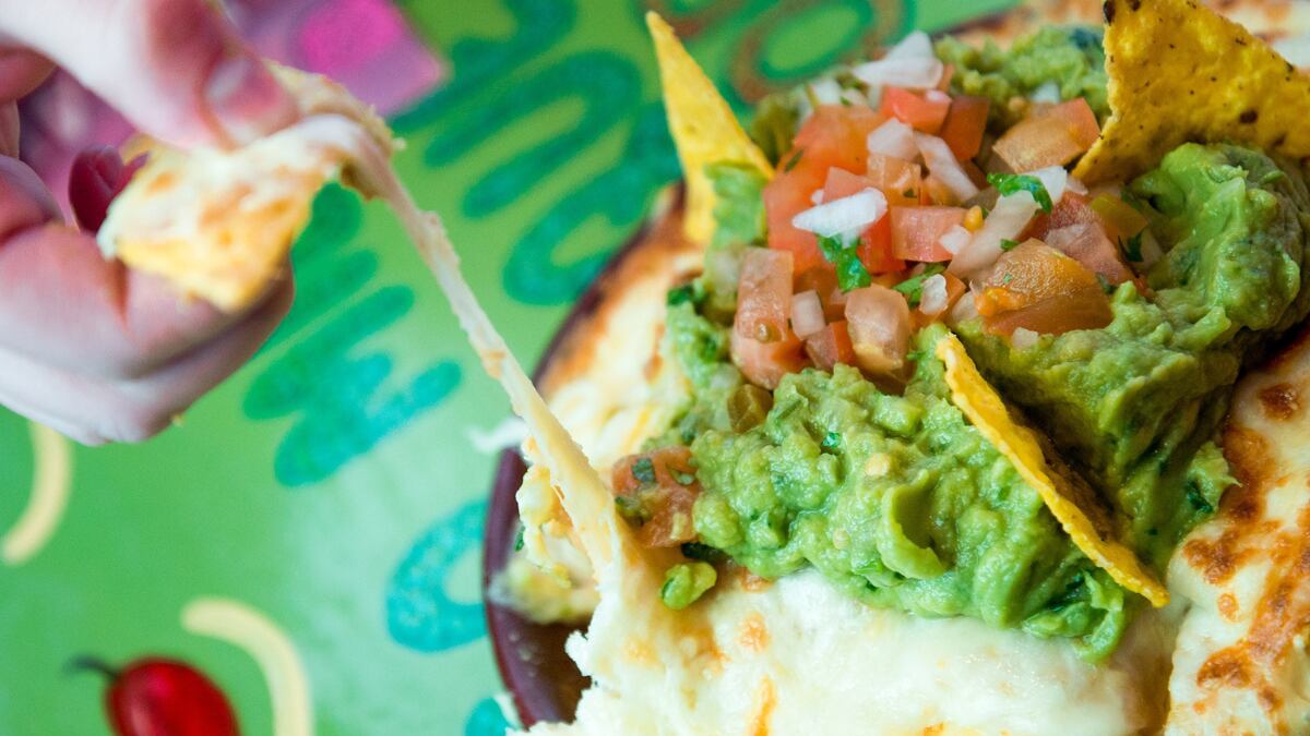 Nachos con guacamole, lleva pico de gallo, fríjoles refritos y queso