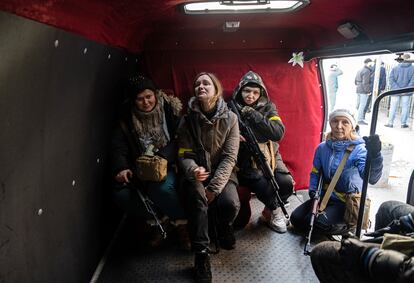 Four civilian volunteers who have just been given weapons await instructions in Kyiv on February 26. 