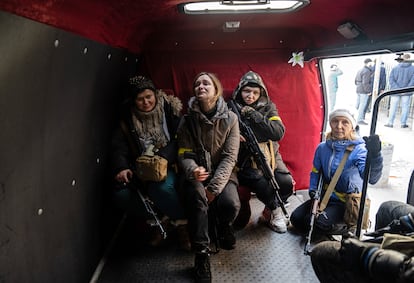 Four civilian volunteers who have just been given weapons await instructions in Kyiv on February 26. 