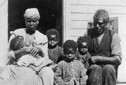 Una familia de esclavos negros sentados en un porche hacia 1850.