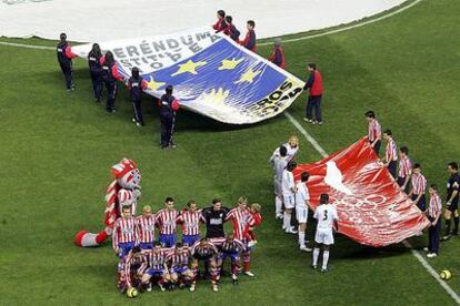 El Atlético posa junto a una pancarta sobre la Constitución europea y otra en favor de Madrid 2012.