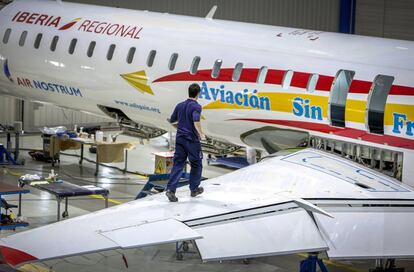 Un operario camina sobre el ala del avión.
