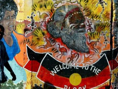 Un aborigen australiano pasa por delante de un mural de arte ind&iacute;gena en Redfern, un barrio perif&eacute;rico de Sidney. 