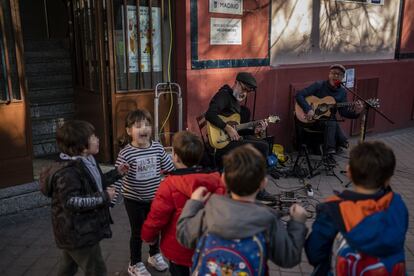 Varios niños bailan y se divierten mientras suena un concierto frente al colegio Fernando El Católico.