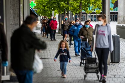 Varias personas hacen cola para hacer la compra en la plaza de Felipe II, en Madrid, el 22 de abril.