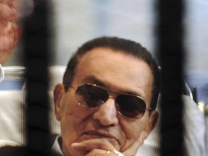 Hosni Mubarak saluda a sus partidarios enjaulado en una sala de audiencias en la academia de policía de El Cairo, en abril de 2013