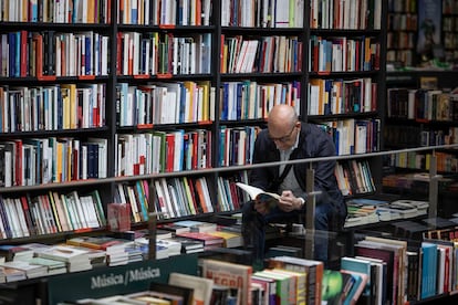 Un lector ojea un libro en una librería de Barcelona.