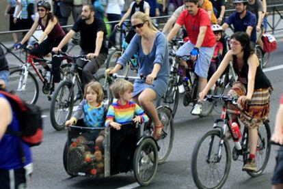 Una madre pedalea con sus dos hijos.