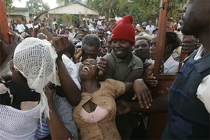 Una mujer intenta entrar a la fuerza a un colegio electoral haitiano, en el pueblo de Marmelde.