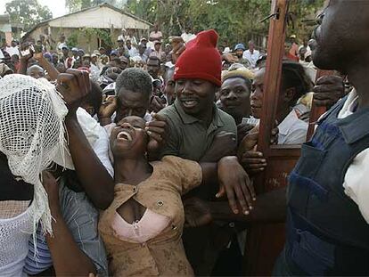 Una mujer intenta entrar a la fuerza a un colegio electoral haitiano, en el pueblo de Marmelde.