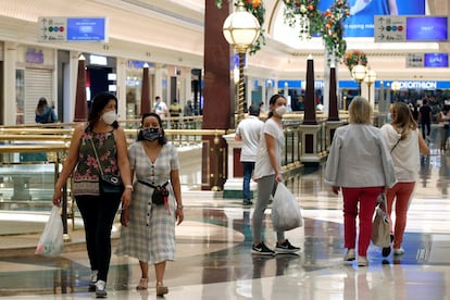 Varias personas pasean por un centro comercial de Barcelona, en junio. 
