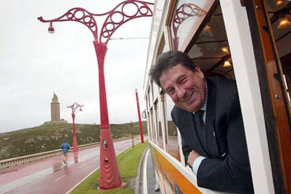 Francisco Vázquez, subido en un tranvía turístico, con la Torre de Hércules al fondo.
