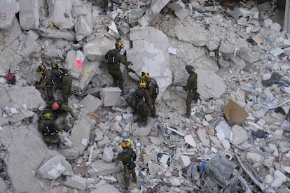 Soldados israelíes buscan entre los escombros de un edificio destruido por un misil iraní cerca de Tel Aviv, este domingo.