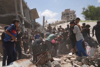 Varios palestinos intentan recoger la ayuda humanitaria lanzada en paracaídas este jueves sobre Gaza.