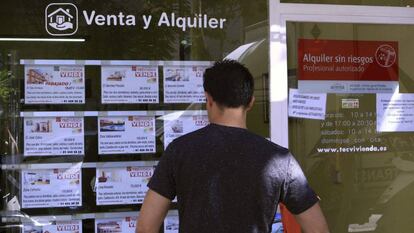 Un hombre mira el escaparate de una inmobiliaria en Madrid. 