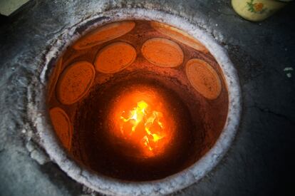 Tortas de 'naan' cociéndose en un tandoor.