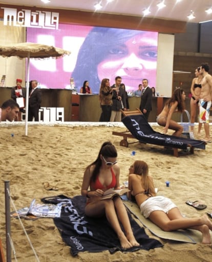 Imagen del expositor de Melilla con varios bañistas y arena de la playa.