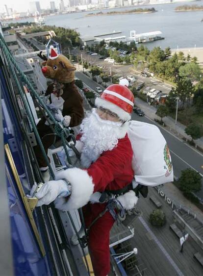 Dos limpiadores de cristales japoneses tratan de hacer su trabajo más ameno en estas fechas y han subido a los rascacielos de Tokio vestidos con los disfraces navideños de Papá Noel y el reno.