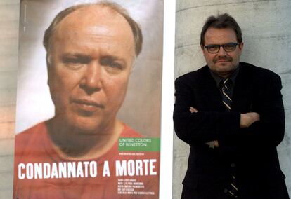 Oliviero Toscani posa junto a un anuncio de Benetton que presenta la imagen del preso condenado a muerte estadounidense David Leroy Skaggs, en el 2000.