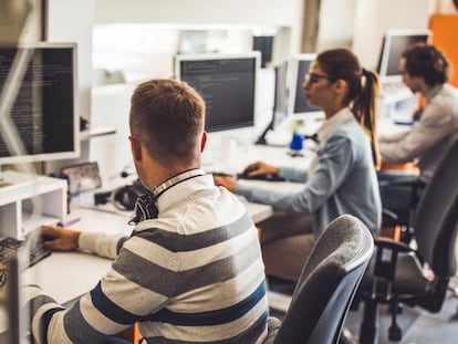 Cuatro profesionales trabajan con sus equipos informáticos.