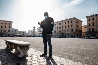 Lansseny, maliense de 22 años que lleva tres viviendo en Italia, lee la lista de la compra antes de ir al mercado de Piazza Cavallotti a por lo que necesita Piero, un livornés de 74 años.