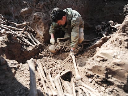 Un arqueólogo excava una fosa de común de soldados soviéticos fallecidos durante la Segunda Guerra Mundial, en el norte de Moscú, en 2009.