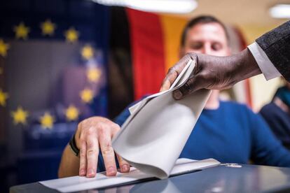 Un hombre deposita su voto en un colegio electoral en Berlín (Alemania).