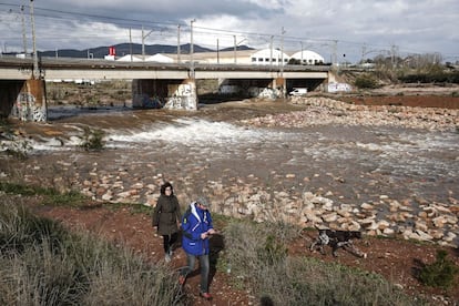 Una pareja junto al habitualmente seco cauce del barranco del río Palancia en Sagunto (Valencia), el 18 de diciembre de 2016.