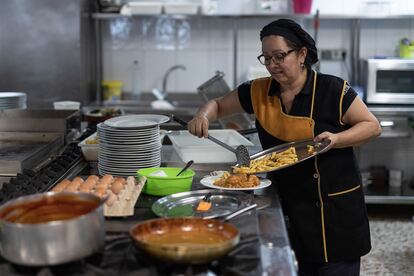 En la imagen, la cocinera Irene prepara un plato de albóndigas en la cocina del bar restaurante Regino en Vía Trajana número 52 de Barcelona.