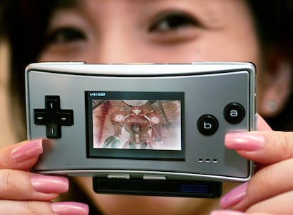 La más pequeña de las consolas portátiles de Nintendo fue presentada fue lanzada al mundo a finales de 2004 . Muy parecida en sus funciones a la Game Boy Advance SP (además de tener cartuchos compatibles). En la imagen, una trabajadora muestra la Game Boy Micro en junio de 2005 en Tokio (Japón).