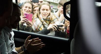 Unas muchachas fotograf&iacute;an a Pablo Iglesias en su furgoneta electoral en Santiago de Compostela, Galicia. 