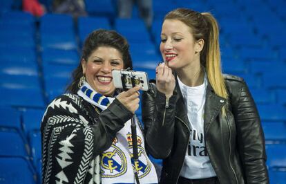 Una aficionada del Madrid se maquilla antes del comienzo del partido.